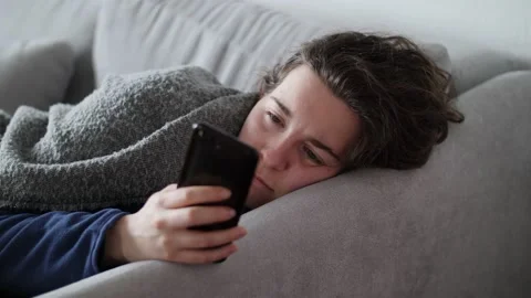 Close up of a bored and depressed young woman looking at her phone on the couch. Stock Footage 150757464