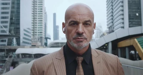 Close-up boss with bald head and beard wearing suit and headphones. Serious Stock Footage 275870541