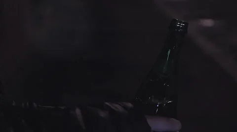 Close up of bottle of beer in the hands at night Stock Footage 67609376