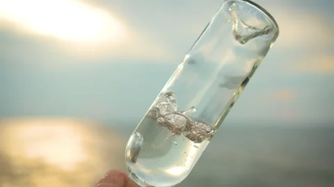 Close up bottle with flows out water against defocused background of sea waves Video stock 252269492