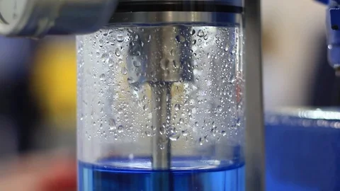 Close-up bottle in the form of a flask with bubbling water and drops Stock Footage 119869630