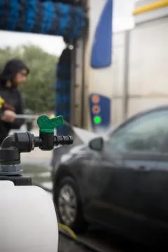 Close Up of a Bottle Full of Soap on Blurred Background of a Man Using Water 库存照片