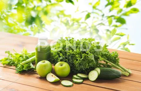 Close up of bottle with green juice and vegetables Stock Photos