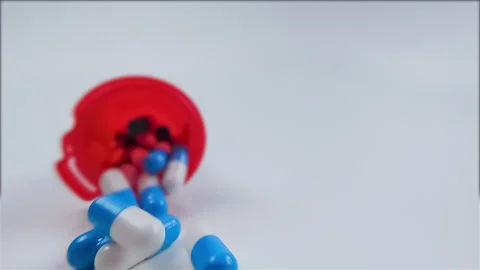Close up of a bottle of pills spilling in slow motion; Covid-19 theme 動画素材 132673579