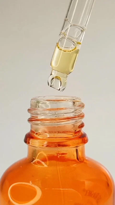 Close up bottle pipette dropper liquid yellow-orange vitamin c or retinol serum Stock Footage 284535252