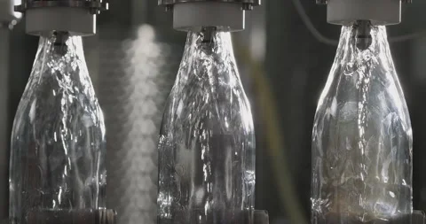 Close-up of bottles filled with white wine by wine bottle filler. Wine bottling Stock Footage 255382208