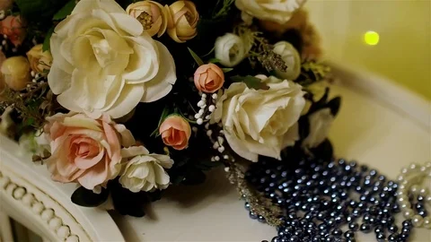 Close-up of bouquet of artificial white and pale pink roses and blue beads on Stock Footage 71107526