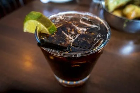 Close-up of bourbon and cola over ice with a fresh lime wedge Stock Photos