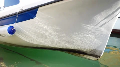 Close-up of the bow of a white boat swaying on the waves on which fall the sun's Stock Footage 201488577