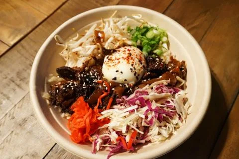 Close up bowl of Barbecue pulled beef on rice with mixed vegetables in Korean st Stock Photos
