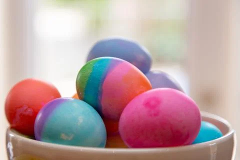 Close up bowl of brightly colored Easter eggs on diplay Stock Photos