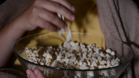 Close up of a bowl filled with popcorn while a hand reaches in to take pieces Stock Footage 336900462