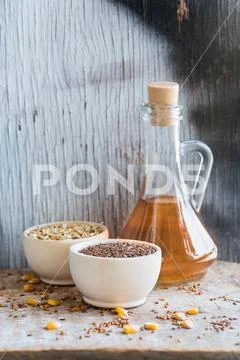 Close up bowl with linseed and decanter of oil Stock Photos