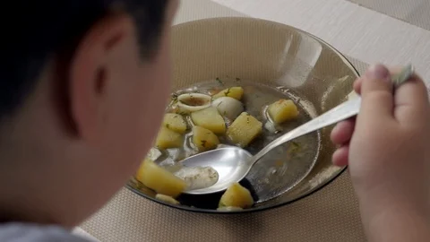 Close-up of bowl of soup, thick junior boy eating Stock Footage 87824880