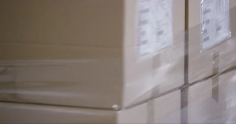Close Up Of Boxes Getting Wrapped In Foil Stock Footage 142888439