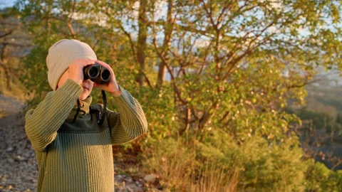 Close up of boy with binoculars exploring forest environment Stock Footage 329770060