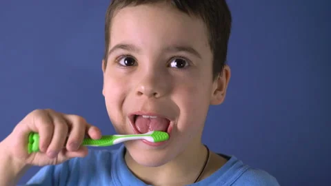 Close-up. Boy brushes his teeth on a blue background 4K Video stock 126806151