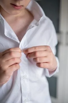 Close-up of boy buttoning his school shirt, getting ready for school Stock Photos