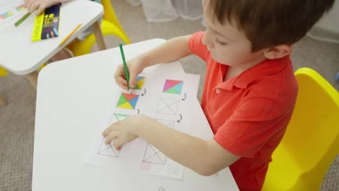 Close-up of a boy at a desk performing a creative task. Stock Footage 253987346