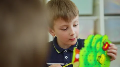 Close-up of a boy doing a task in kindergarten. Educational lessons for children Video stock 247992150