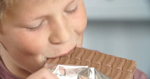 Close Up Of Boy Eating Bar Of Chocolate Stock Footage 53519148