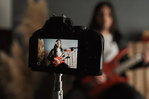 Close-up of a boy filming himself while playing the bass guitar Foto stock