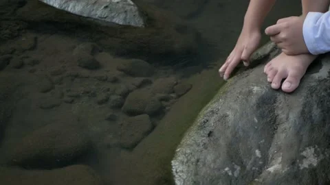 Close up of a boy hand playing with clean water in a river Stock Footage 210101926