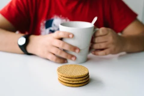 Close up of boy having a breakfast with biscuits, focus on biscu Stock Photos