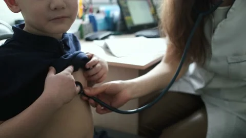 Close-up of a boy having his lungs checked with a stethoscope Video stock 234255091