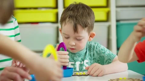 Close-up of a boy in kindergarten playing logistic games for hand motor skill Stock Footage 244850964