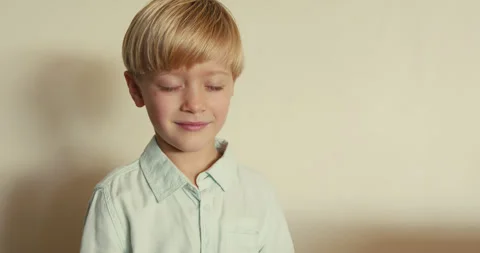 Close-up of a boy making a Shhh gesture, pressing his index finger to his lips Video stock 346982874