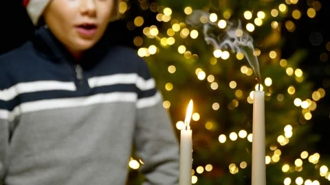 Close-up of a boy in a New Year's hat blows out the candles. New Year Stock Footage 167238309