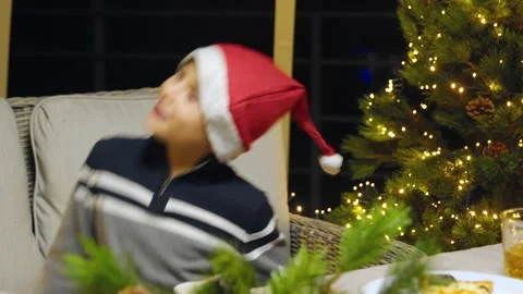 Close-up of a boy in a New Year's hat dancing on the couch for the New Year. New Stock Footage 167239276