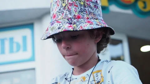 Close up of a boy opening and drinking lemonade. Teen boy walking on the street Stock Footage 247750815