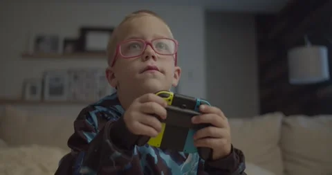 Close-up of boy playing Nintendo Switch Video stock 253741057