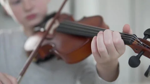 Close-up, the boy plays the violin at home, the focus on his fingers and the Stock Footage 145413248