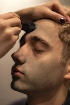 Close-up of a boy putting on make-up Stock Photos