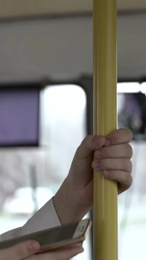 Close up of a boy riding a city bus, gripping a yellow handrail with one hand  Stock Footage 344768290