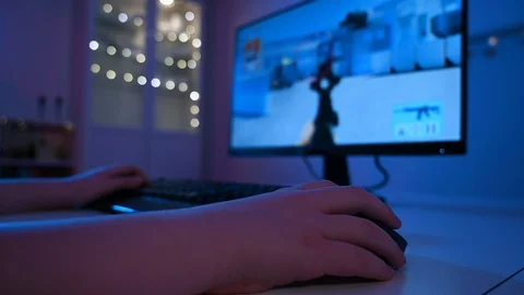 Close up of boy using a computer mouse at night while playing video games Stock Footage 100795580