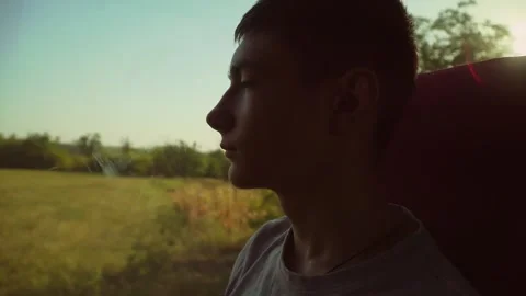 Close up boys face looking to window in moving car. Darkened. Evening dusk in Stock Footage 270458276