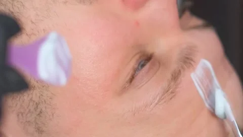 Close-up of the boy's face while applying the mask. A guy at a beautician Video stock 250356544