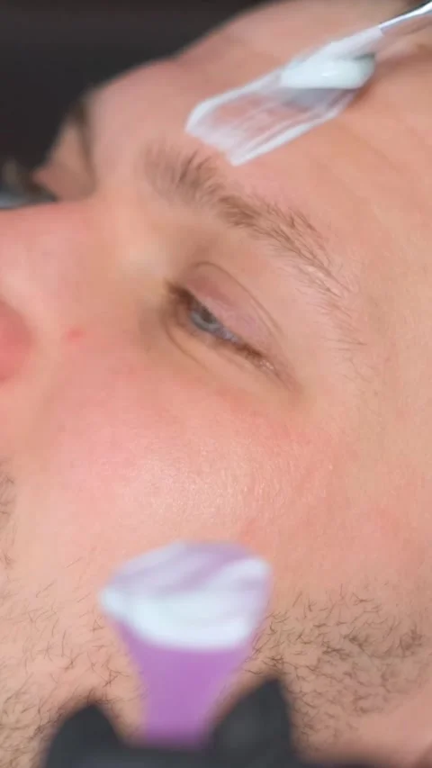 Close-up of the boy's face while applying the mask. A guy at a beautician Stock Footage 250382824