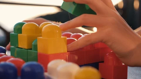 Close-up of the boy's hand collecting the developing designer of the lego Stock Footage 94508009