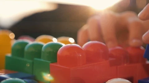 Close-up of the boy's hand collecting the developing designer of the lego Stock Footage 94557260