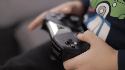 Close-up of boy's hands holding a controller and playing video game Stock Footage 102416132