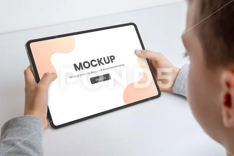 Close-up of a boy's hands holding a tablet mockup Modello PSD