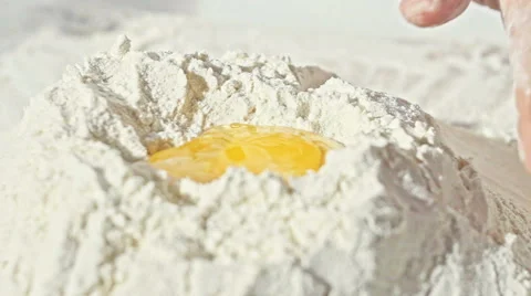 Close up of boy's hands with plain flour well and eggs in preparation process Stock Footage 67869948