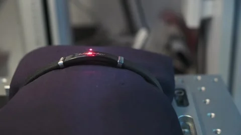 A close up of a bracelet with a red light illuminating it Stock Footage 276289073