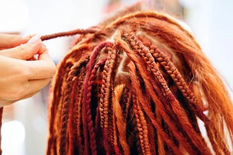 Close up of braiding process african plaits with colored kanekalon. Stock Photos