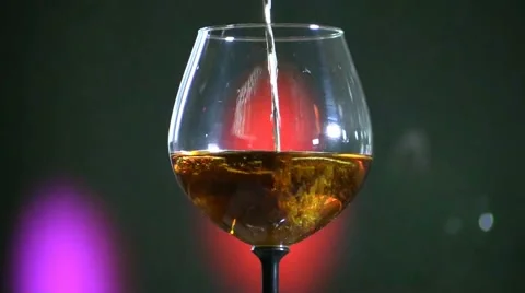 Close up of brandy being poured into snifter against colorful background 스톡 동영상 57859996